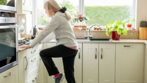 older woman practicing single leg balance training exercises at home