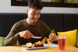 man eating a balanced meal at a dining table without phone or television, natural American home setting